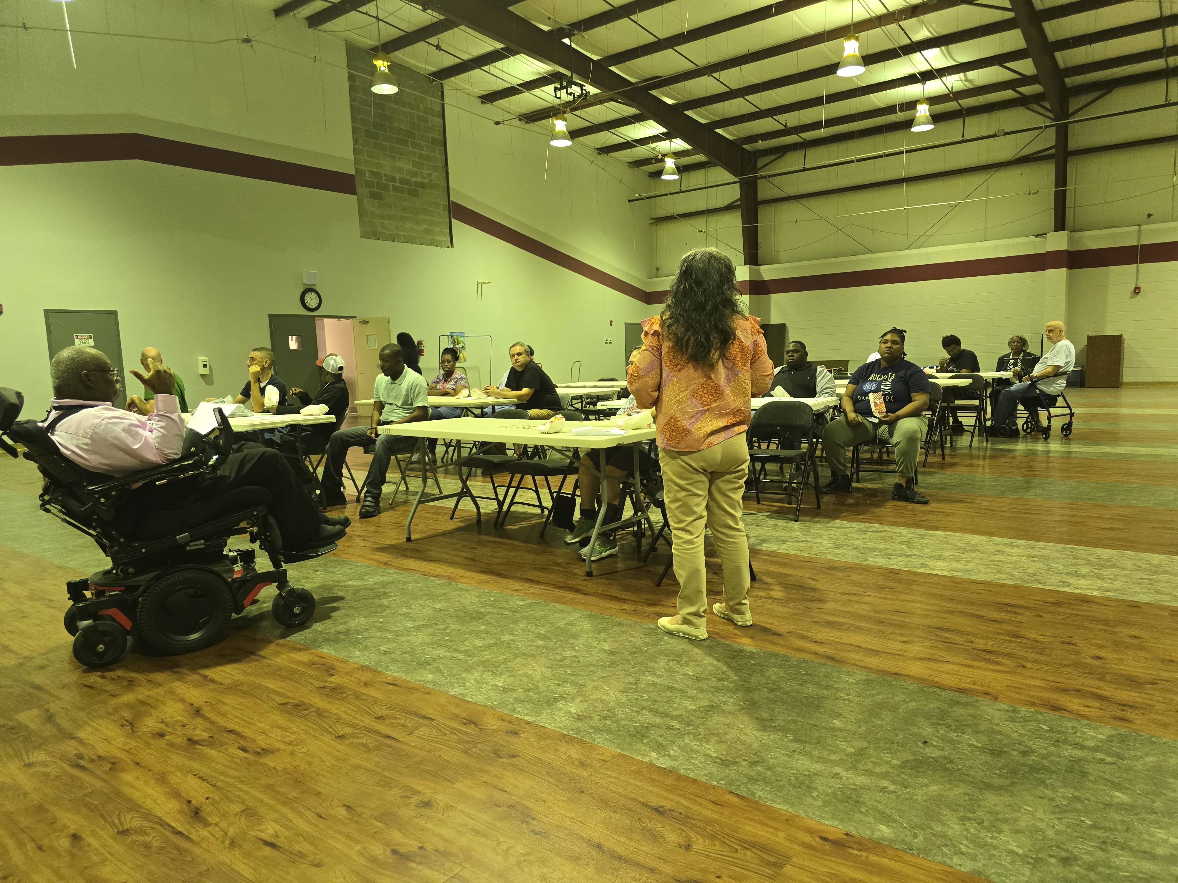 Attendees listening to Ms. Ester speak since Mr. Johnson's voice was not heard from everyone.