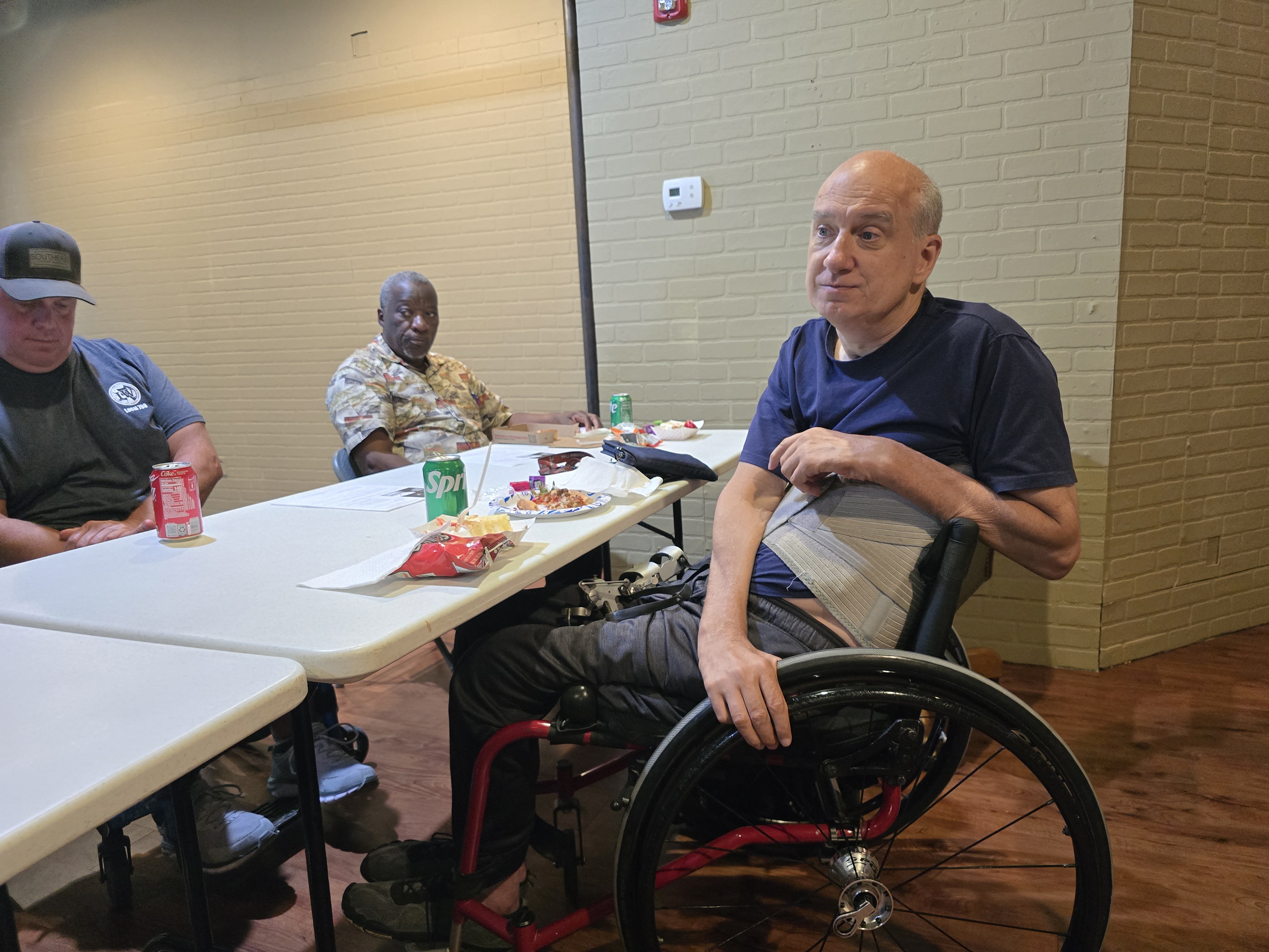 SCI Support Group April 2026 meeting members eating lunch with Robert.