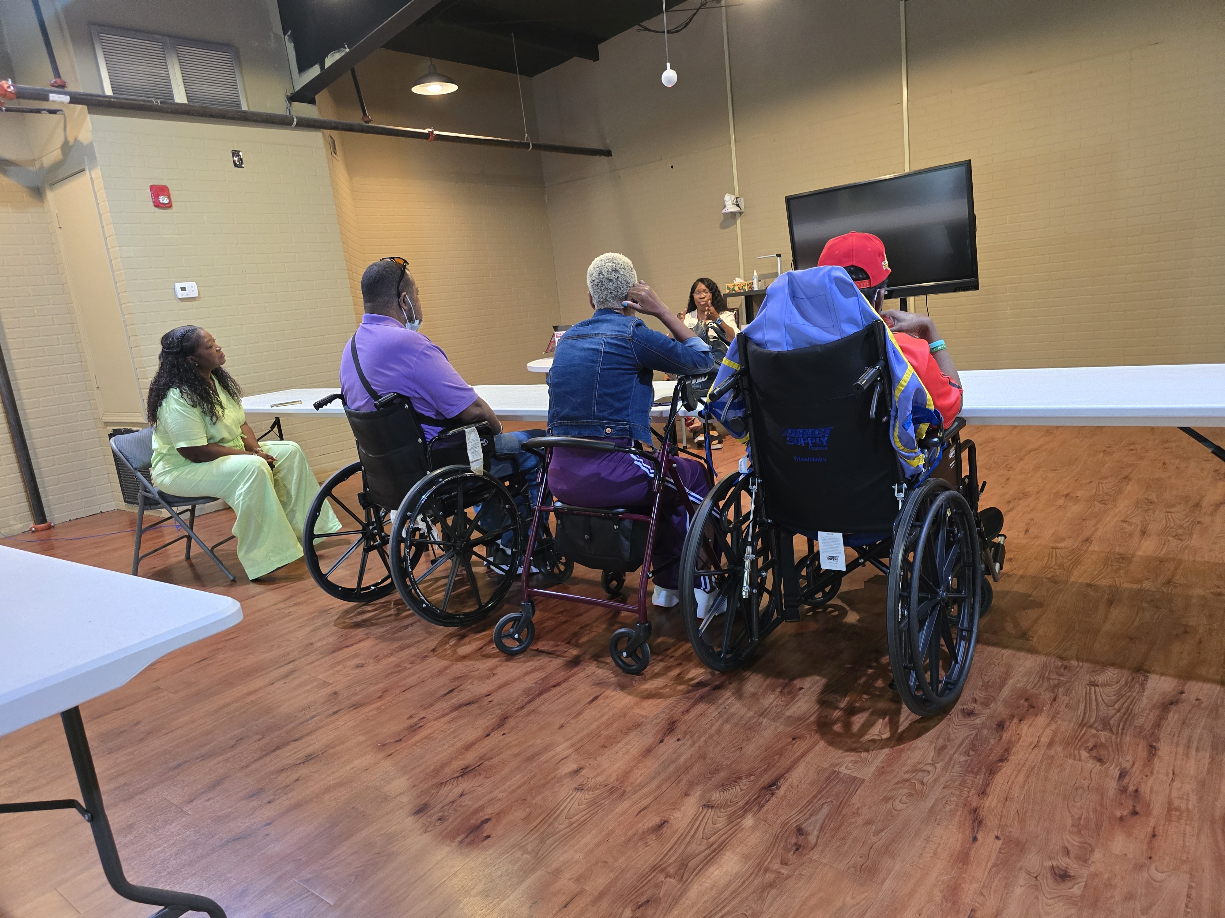 Spinal injury support group talking, incorporating activities to make future group meetings more enjoyable.