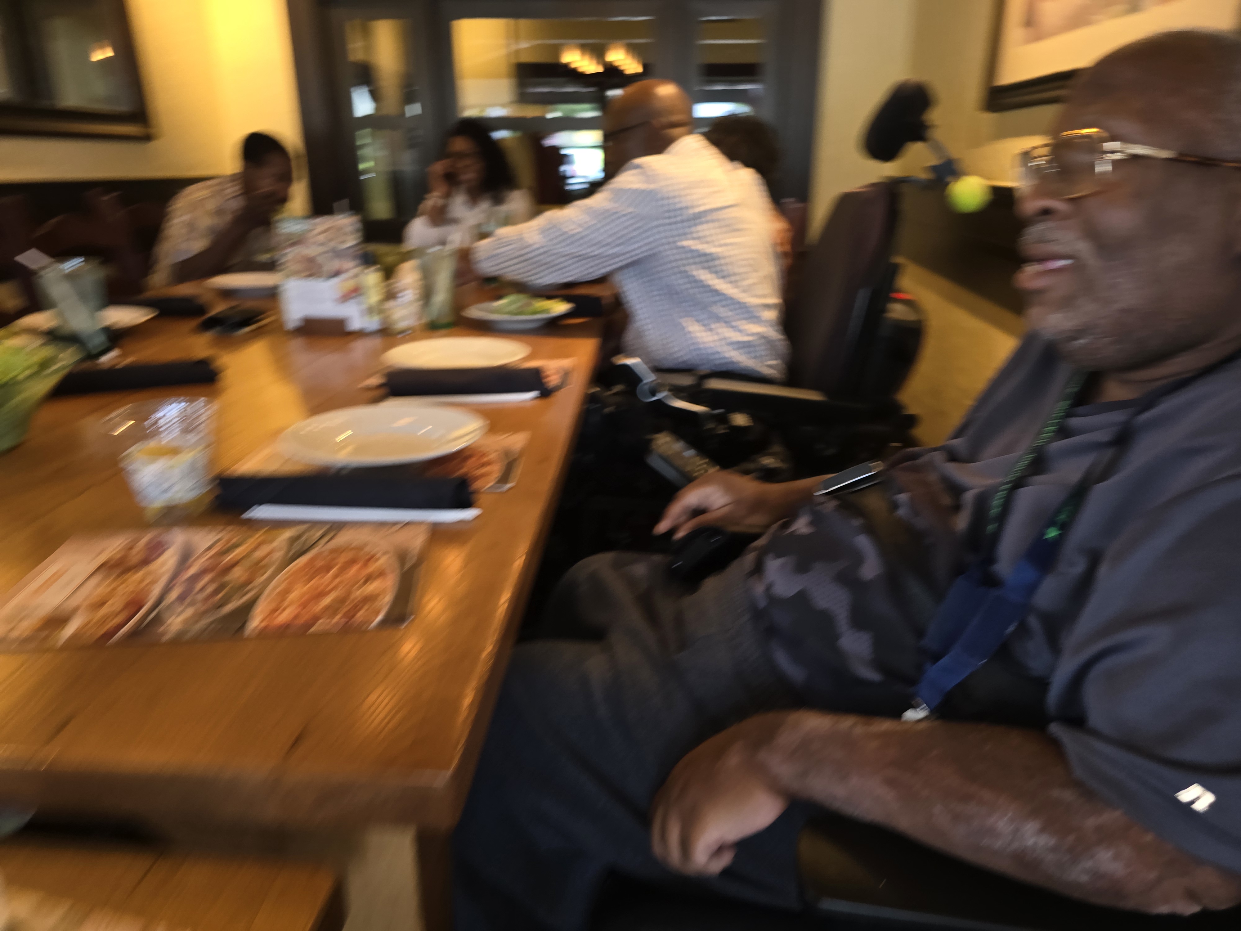 Another angle and blurry photo of the spinal injury support group out to eat at Olive Garden. Chris, Lesia, Jerry, his wife, and Brian are all in the photo.