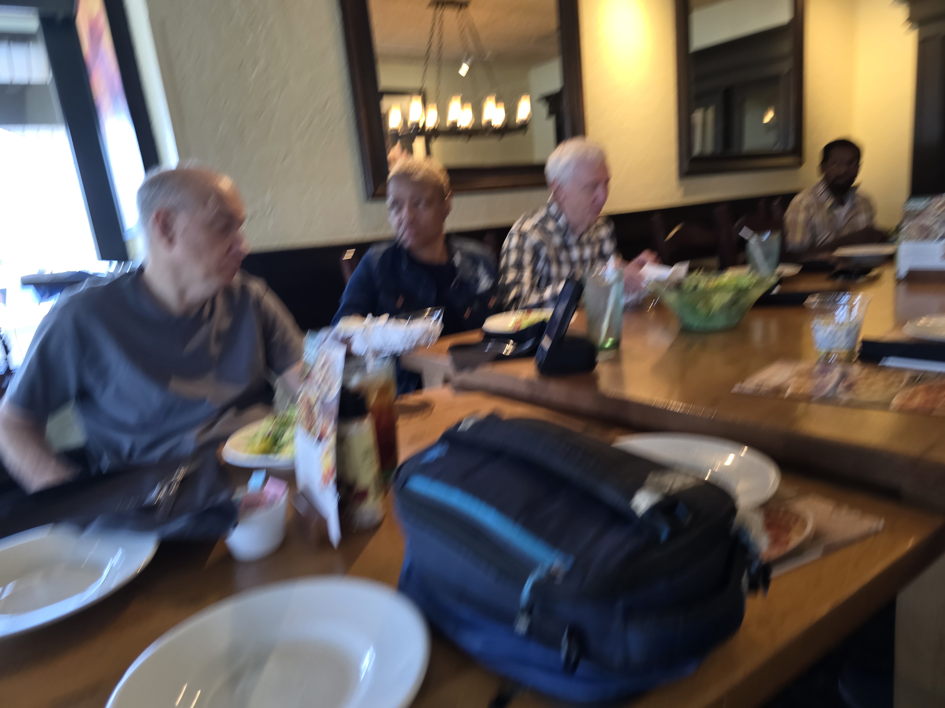 Another angle and blurry photo of the spinal injury support group out to eat at Olive Garden. Robert, Kim, Jim, and Chris are all in the photo.