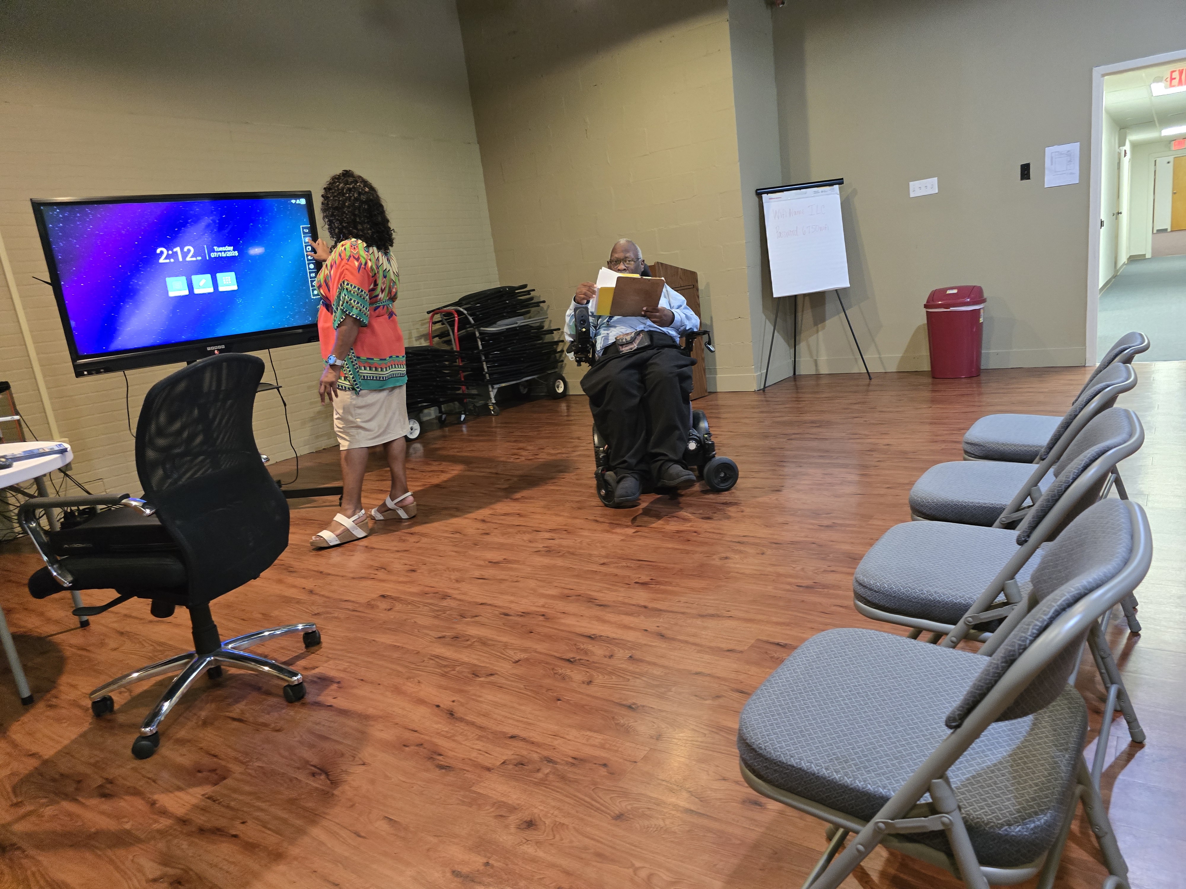 Leisa Daily working the TV equipment and Brian Johnson speaking.