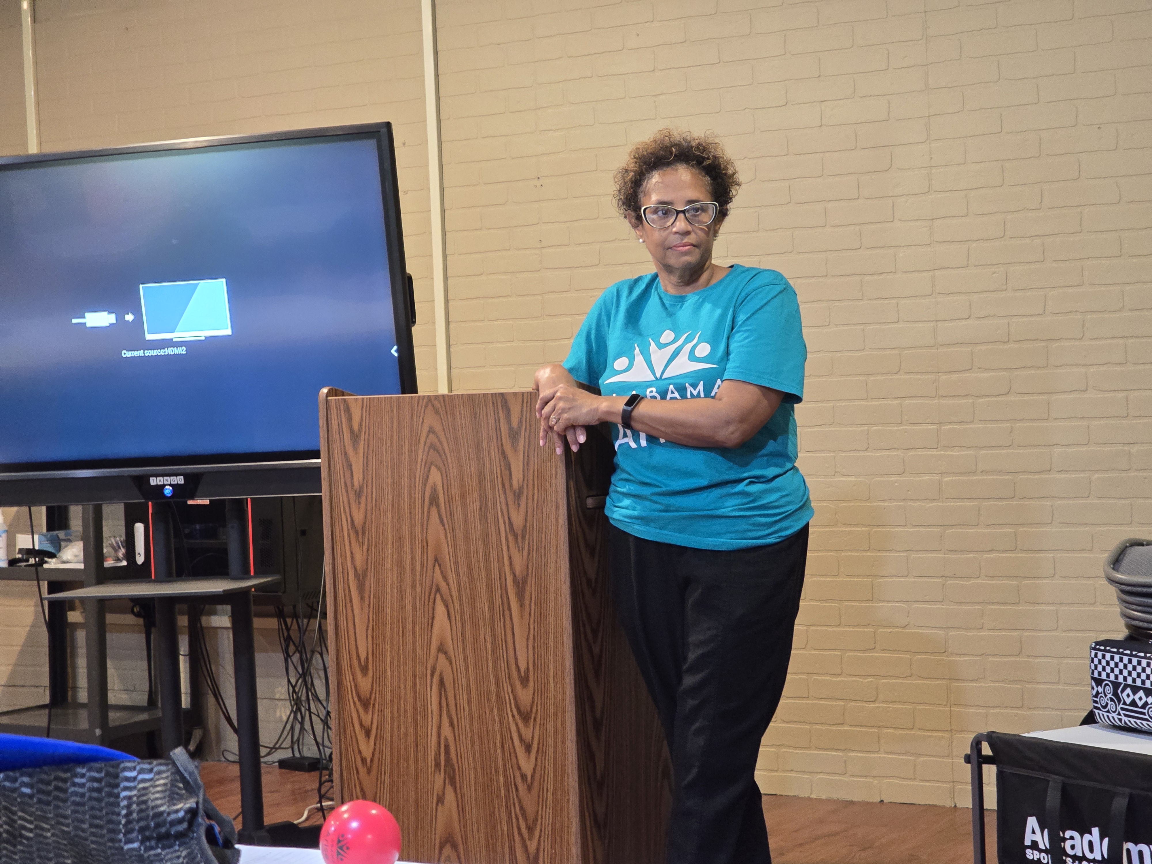 Ms. Allen of Alabama Arise stands at the podium after her presentation, underscoring her commitment to a better Alabama for all.